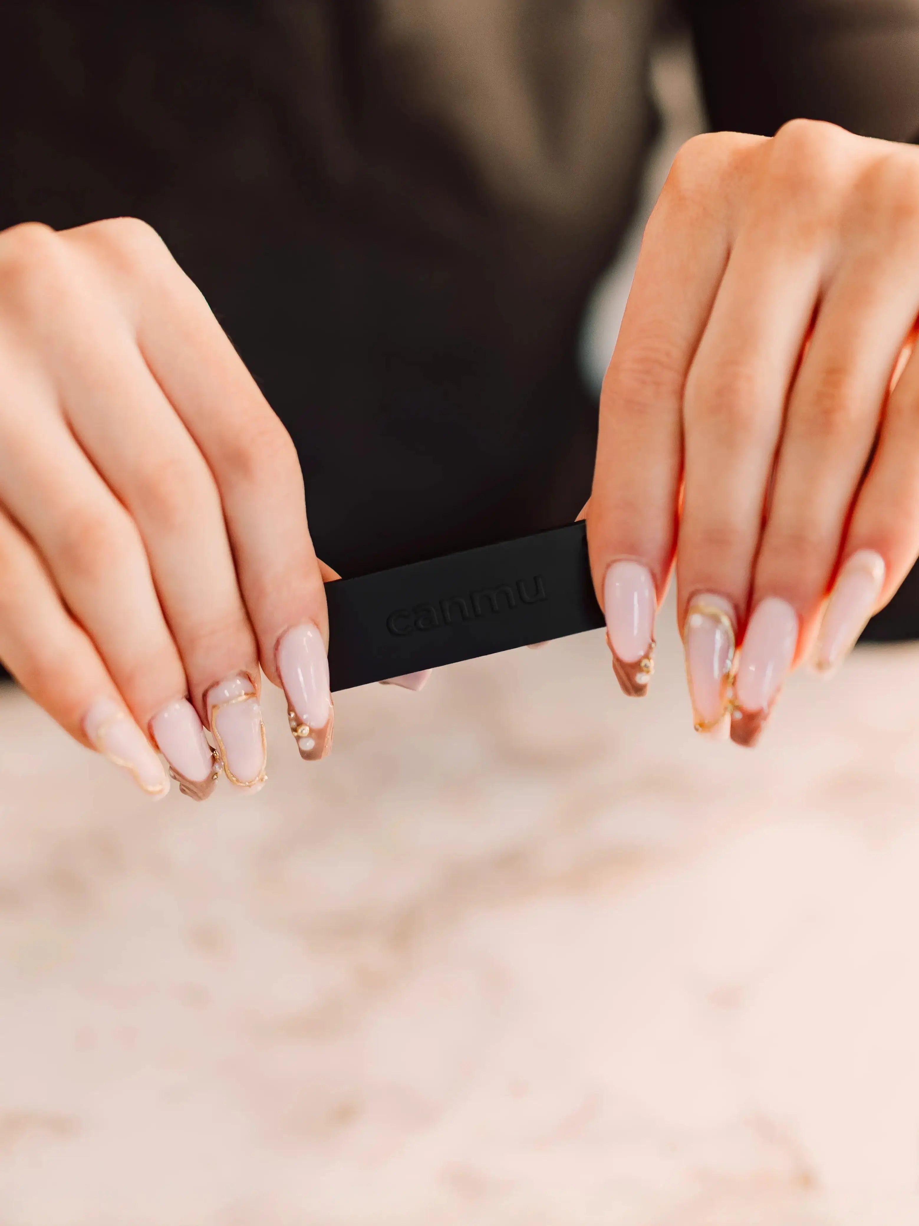 black canmu product held with long nails